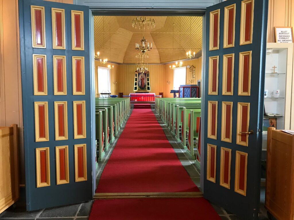 The colourful interior of its church, typical of Laestadian congregations, perfectly complements the traditional Sámi gákti—bright blue garments trimmed with vivid red and yellow details. 