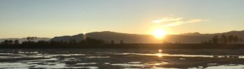 Midnight sun near the fjord in Norway during the low tide, high above the Arctic Circle, near Alta